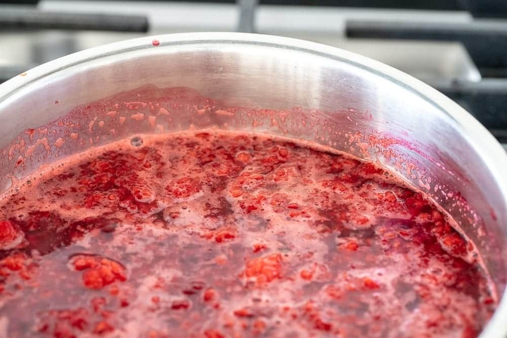 The Best Thick Raspberry Sauce | Family Cuisine 9 woman mixing raspberry sauce in pan