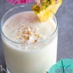 virgin pina colada in a glass with a umbrella and pineapple wedge.