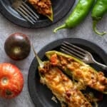 Anaheim Stuffed Peppers on black plates with antique forks.