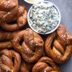 Whole Wheat Pretzels on a wooden cutting board with dipping sauces.