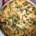 Chicken and spinach pasta in a cast iron skillet.