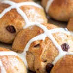 Whole wheat hot cross buns on a baking sheet.
