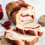 raspberry swirl bread sliced on a piece of parchment paper.