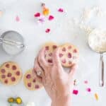 Edible flower shortbread cookies on a piece of parchment paper.