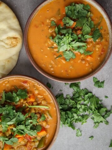 Two bowls of lentil curry soup on the table.
