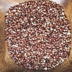 Red popped quinoa in a wooden bowl.