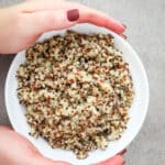 Cooked tricolor quinoa in a white bowl.