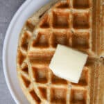 Oat flour waffles on a white plate.