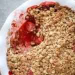 Strawberry crumble in a white pie pan.