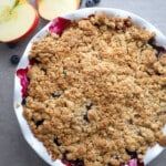 Apple blueberry crumble in a white pie plate.