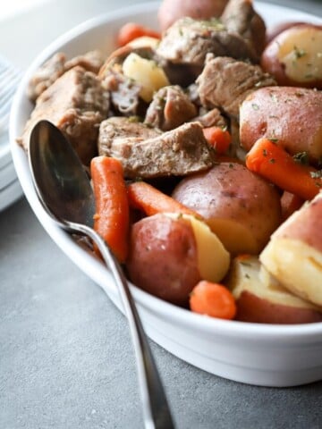 Pork Tenderloin and potatoes in a white dish.