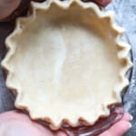 Woman holding a homemade pie crust.