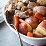 Pork Tenderloin and potatoes in a white dish.