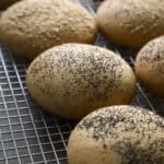 Hamburger buns cooling on a cooling rack.