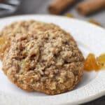Oatmeal raisin cookies on a small white plate.