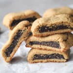 Fig newton cookies stacked together on a piece of parchment paper.