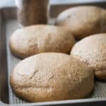 Einkorn pizza dough balls on a metal pan.