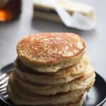 Stack of brown rice flour pancakes on a black plate.