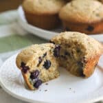 Blueberry muffin on a white plate.