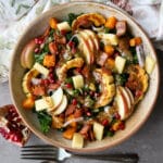 Fall kale salad in a ceramic bowl with a napkin on the side.