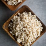 Cooked barley in a wooden bowl.