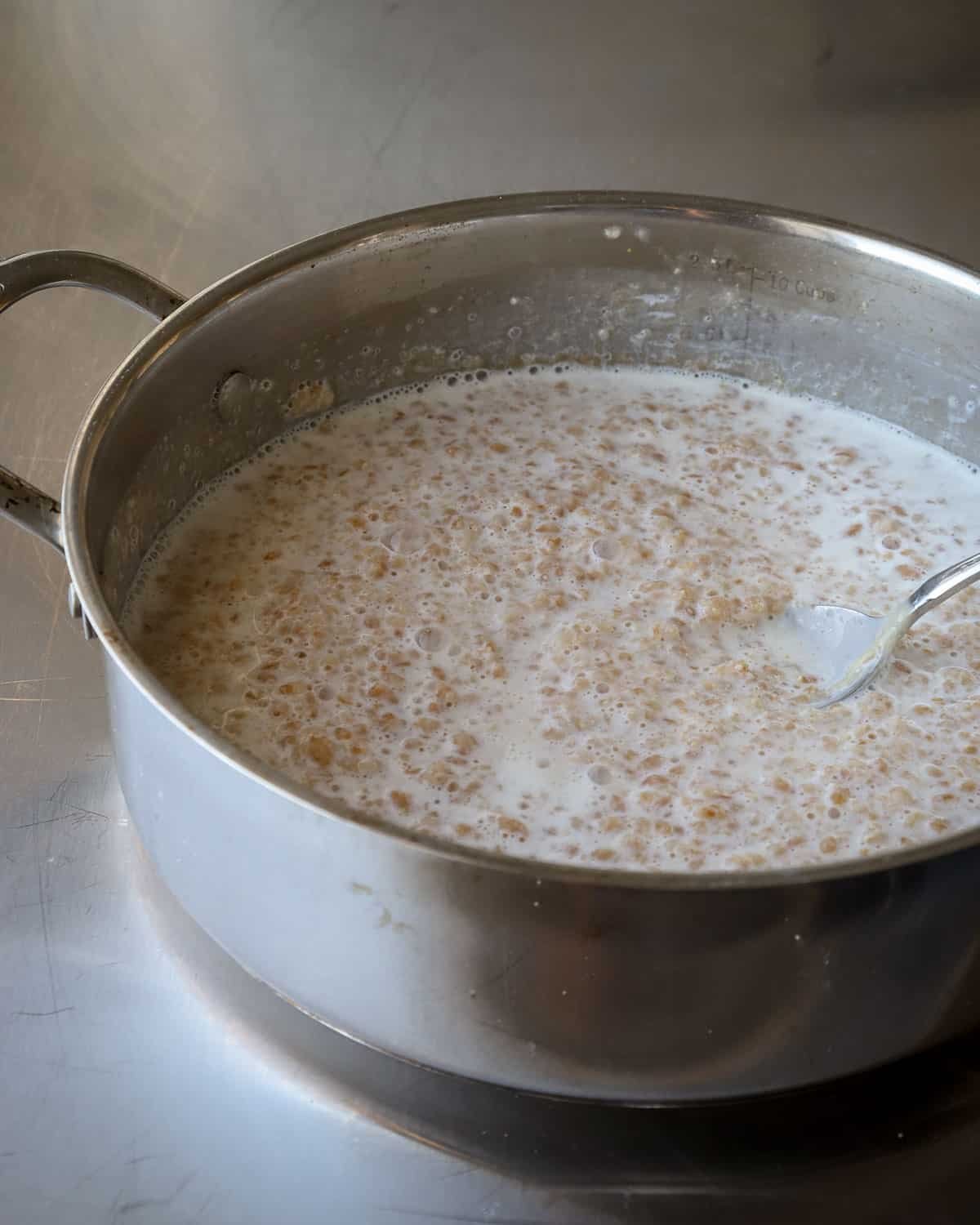 Cracked einkorn porridge in a stainless steel pan.
