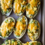 Twice baked potatoes with cheese on top melted.