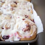 Raspberry lemon rolls on a baking sheet pan lined with parchment paper.
