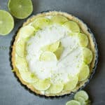 No bake lime cheesecake with lime slices and zest on top.
