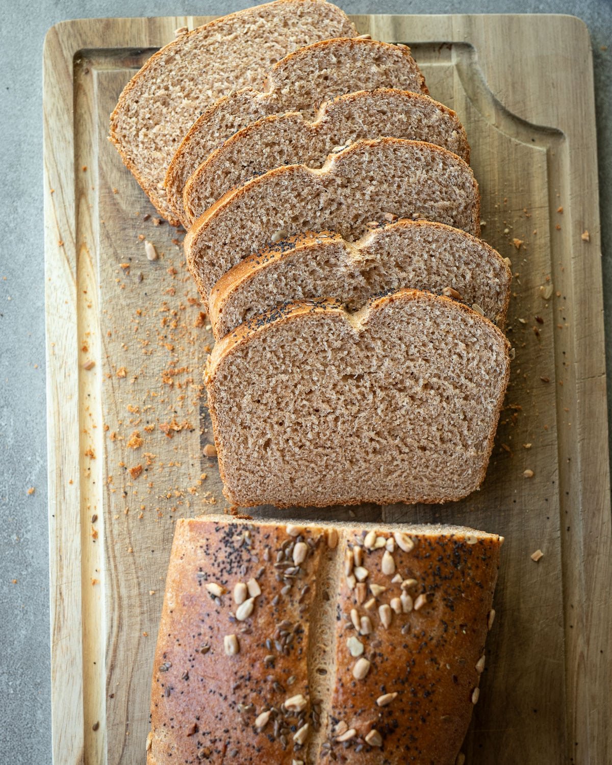 Sliced sprouted wheat bread on a wooden cutting board.