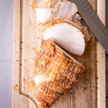 Sliced lunchmeat on a wooden cutting board.