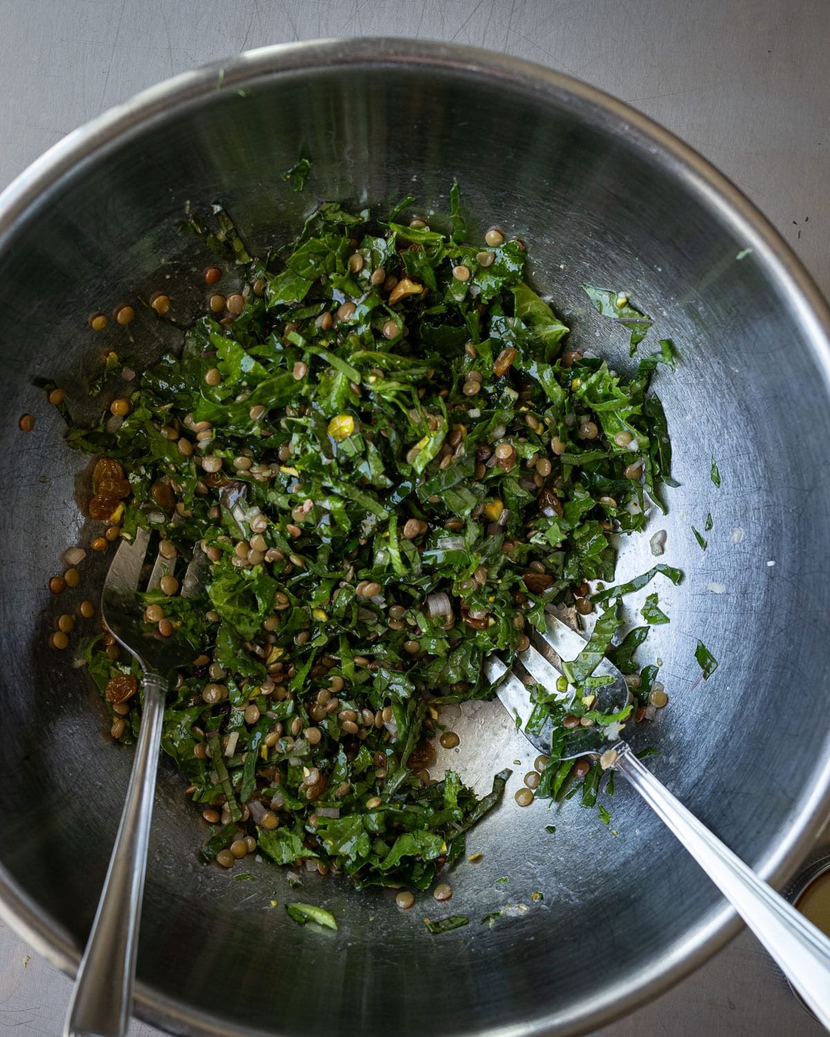 Kale salad in a large metal mixing bowl. 