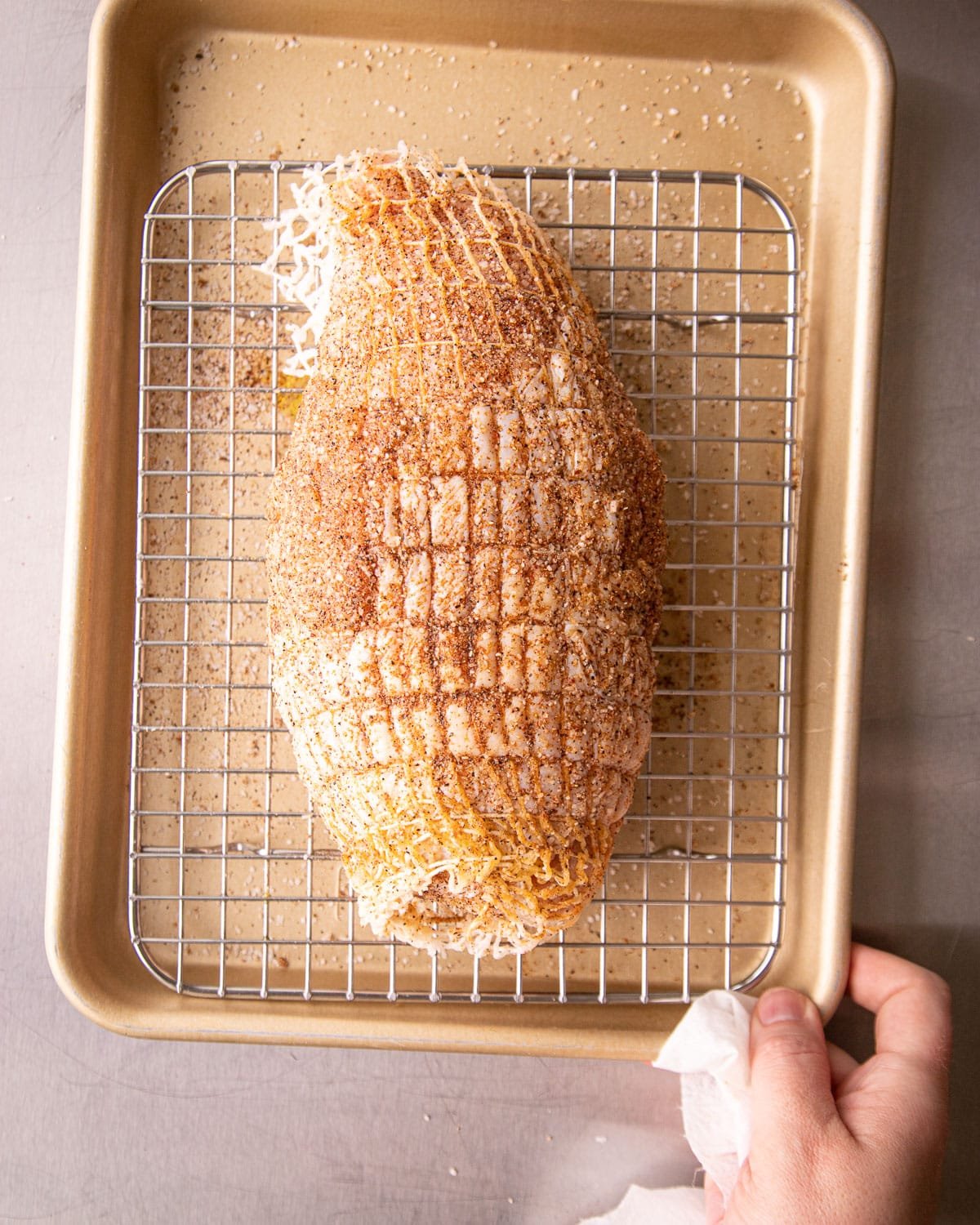 Turkey breast for baking on a cooling rack on a pan. 