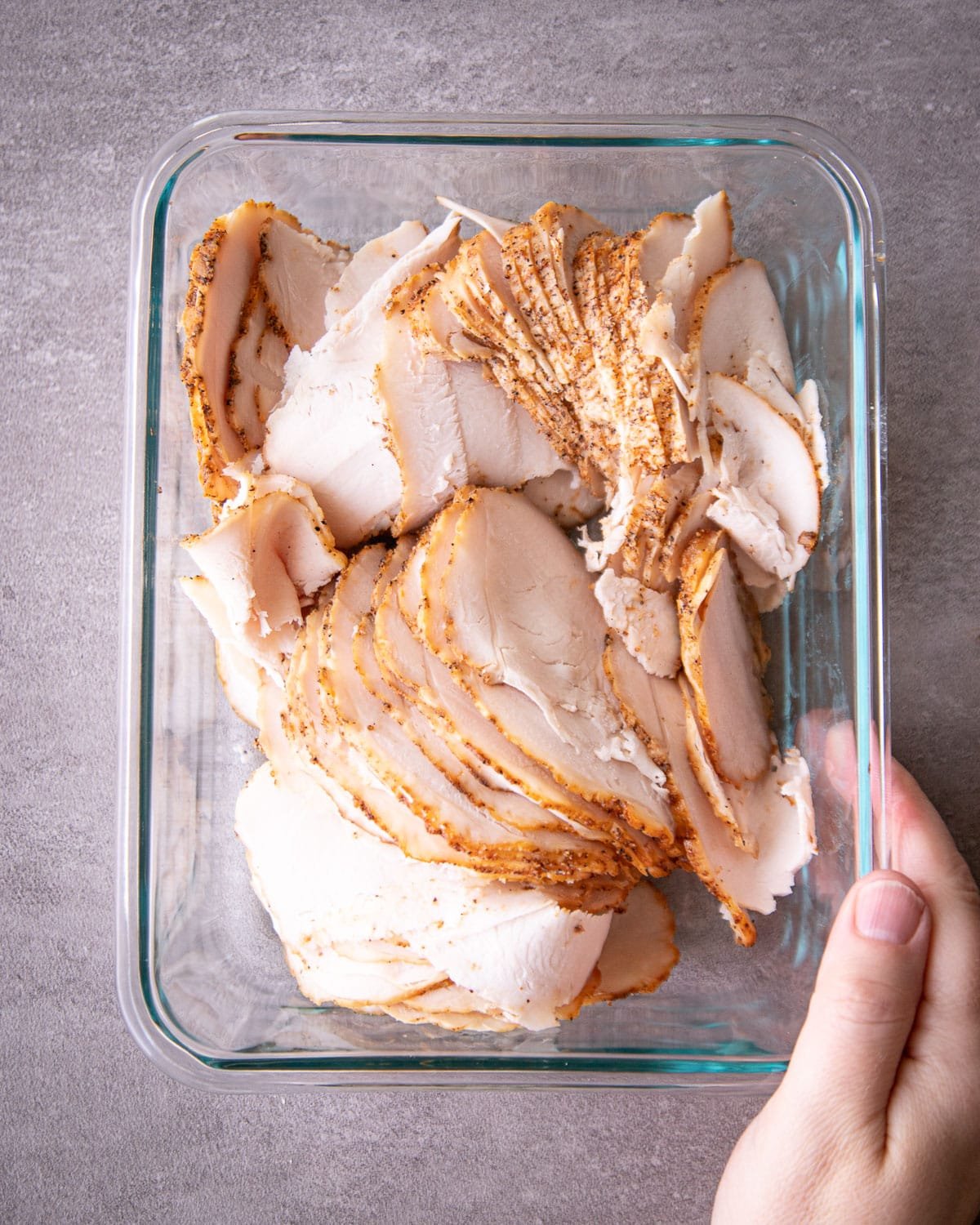 Sliced turkey breast in a glass container. 