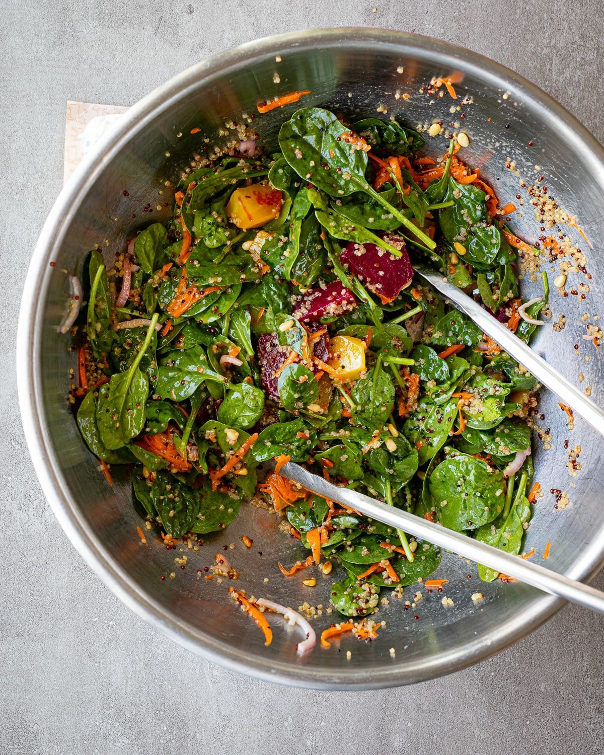 Salad mixed in a large metal bowl. 