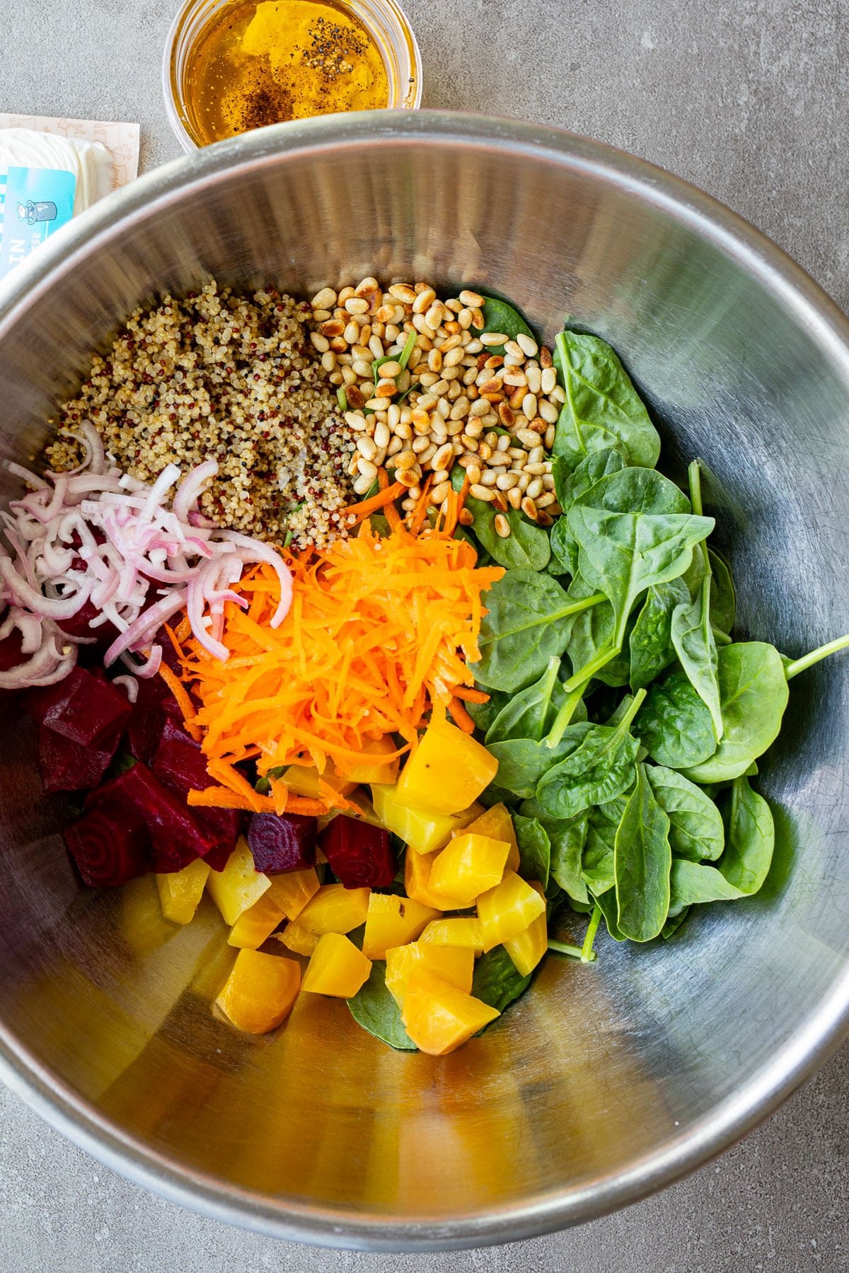 Ingredients for a salad in a large metal bowl.