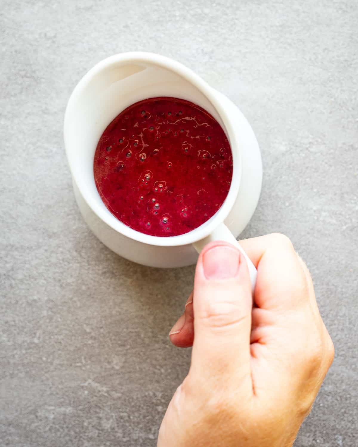 Cherry vinaigrette in a small white serving pitcher. 