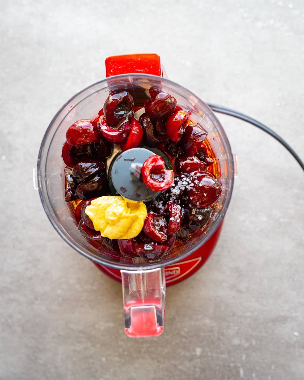 Ingredients for cherry dressing in a small food processor. 