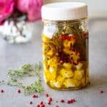 Marinated mozzarella balls in a mason jar with garlic and herbs.