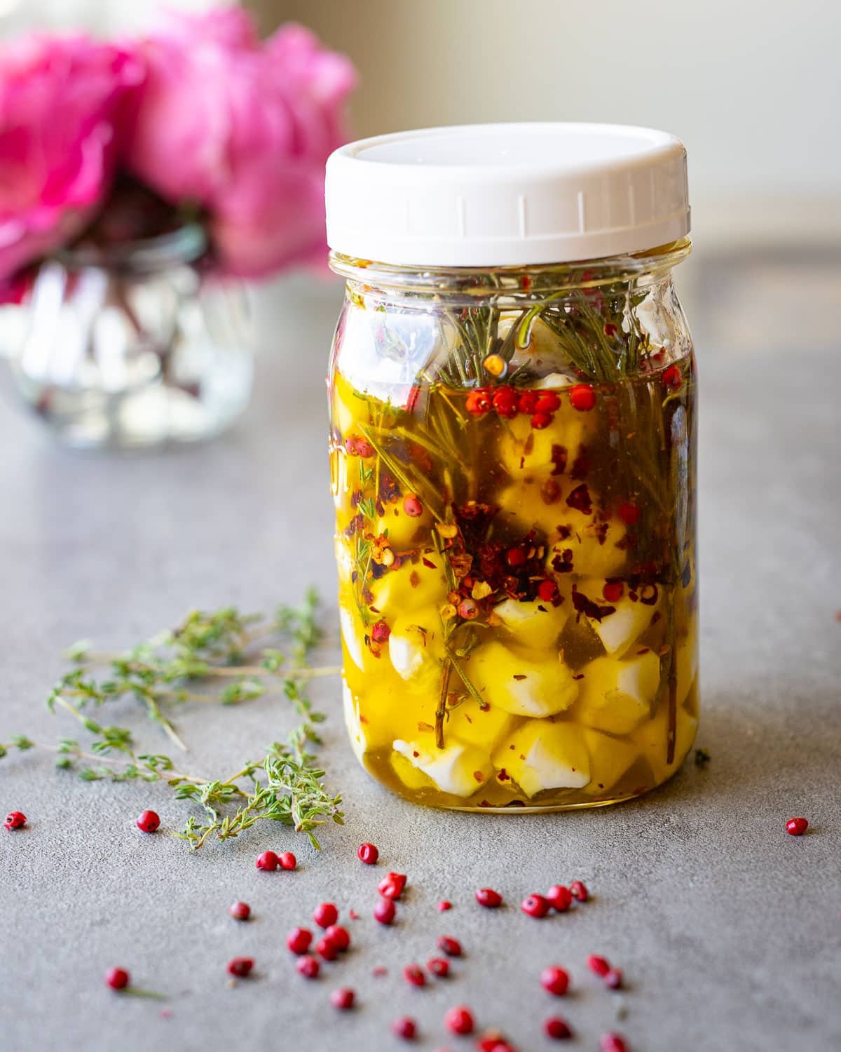Marinated mozzarella balls in a mason jar with garlic and herbs.