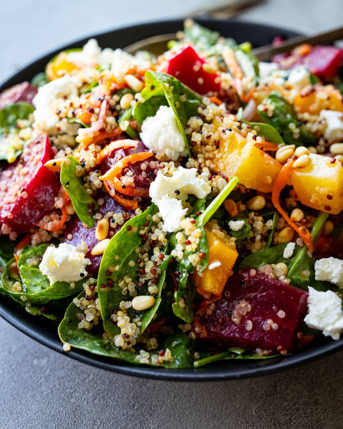 Roasted beet and quinoa salad in a black bowl. 