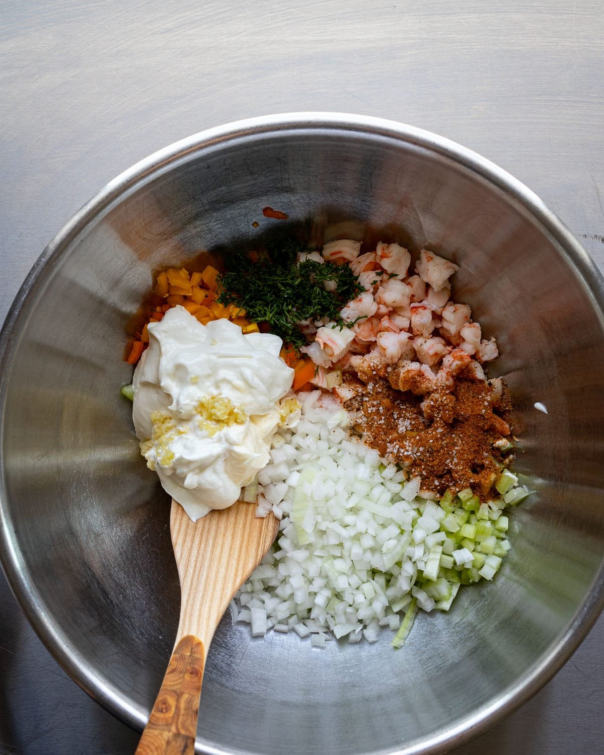 Salad ingredients in a large metal bowl.