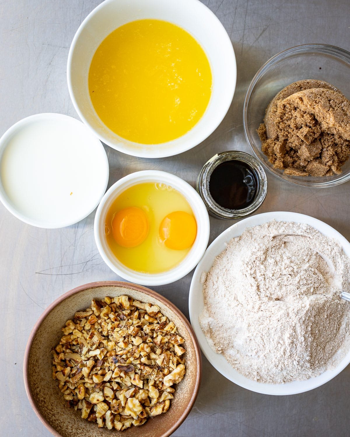 Ingredients for muffins in small bowls on a surface. 