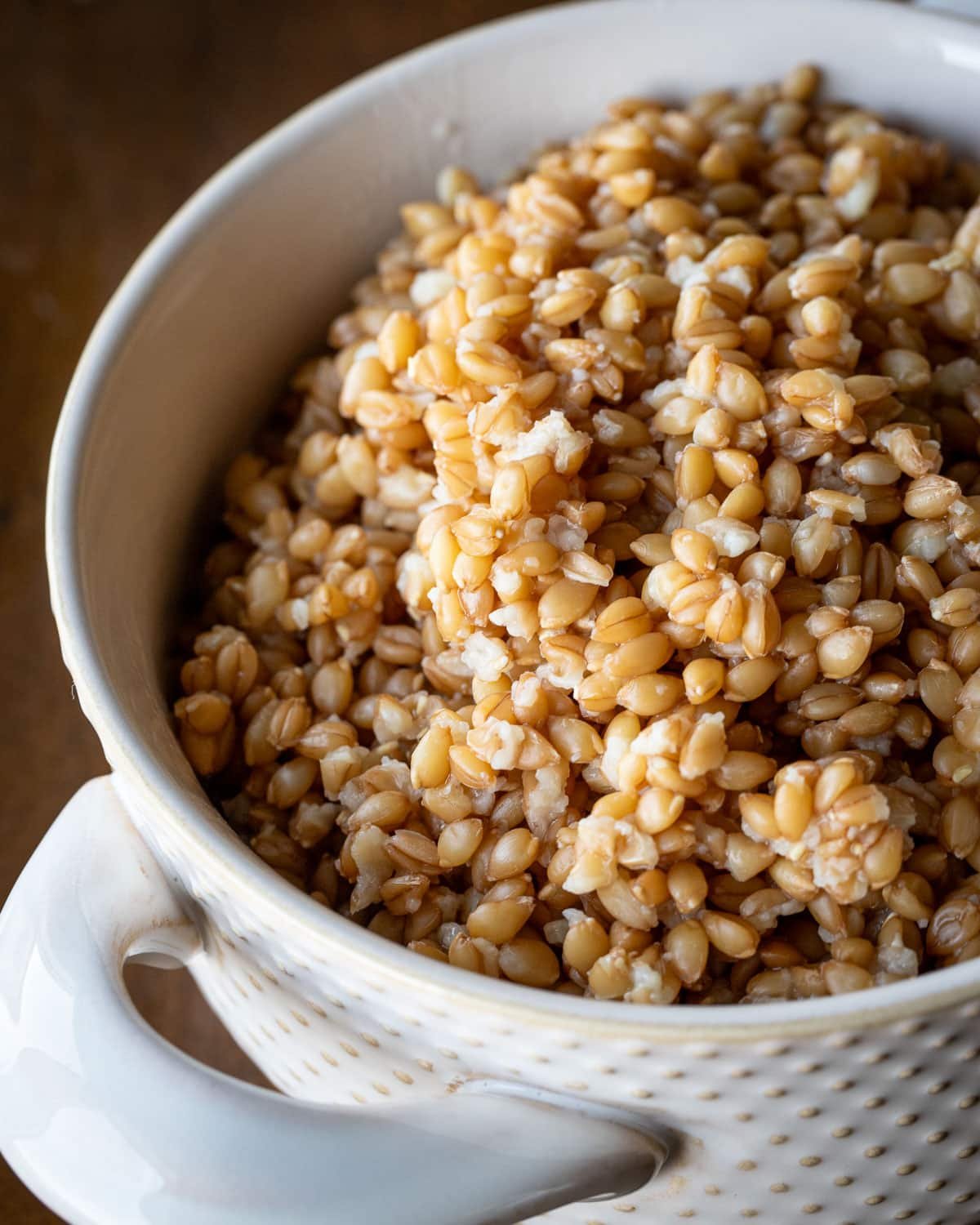 Cooked einkorn in a white serving bowl.