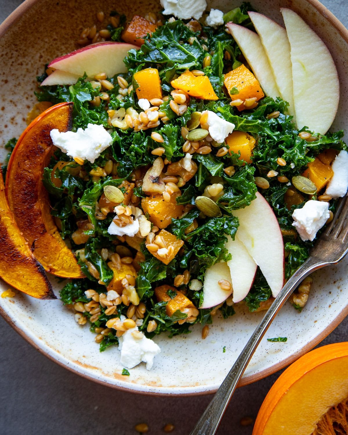 Grain bowl with kale and butternut squash in a ceramic bowl.