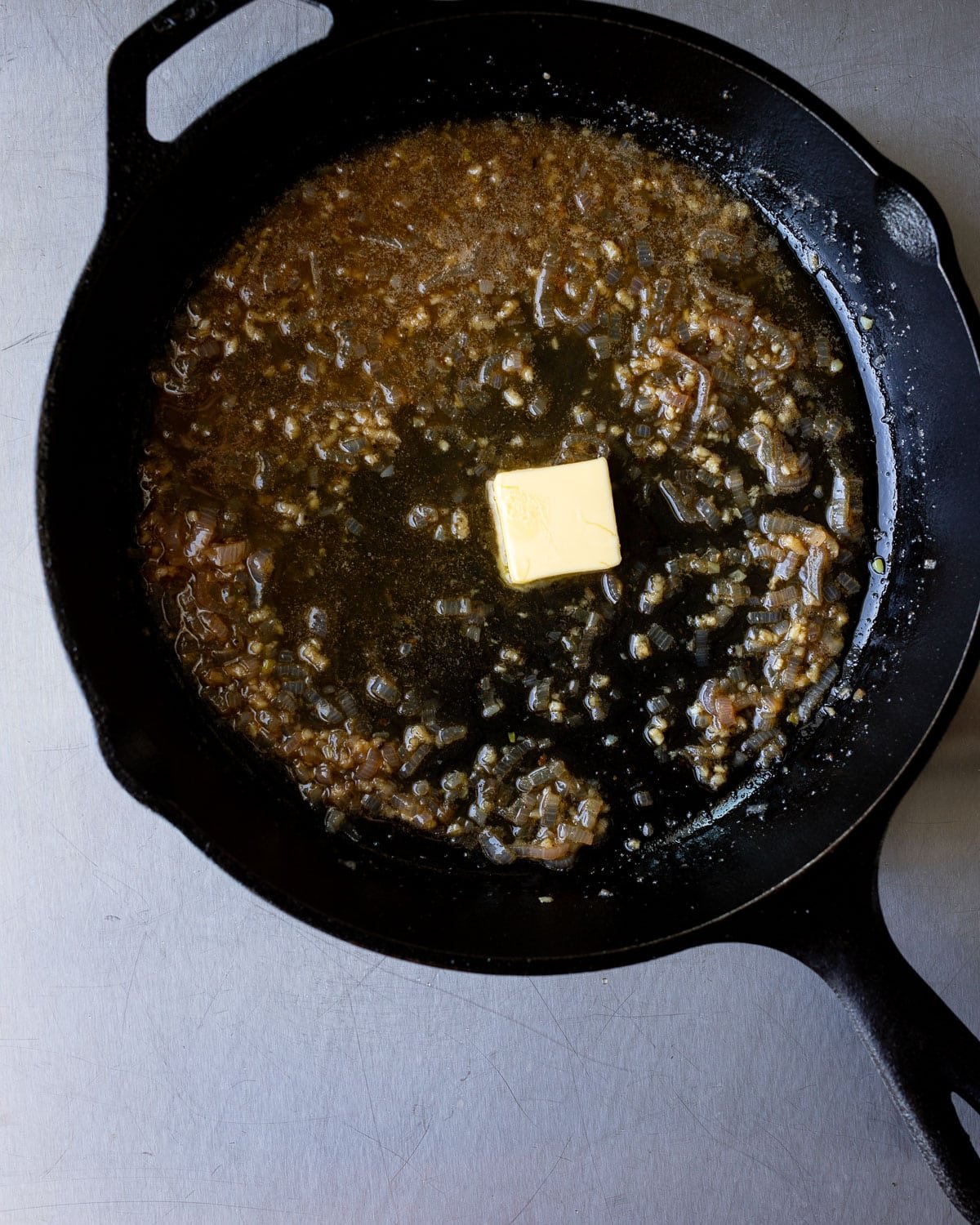 Butter and shallot sauce in a cast iron pan. 