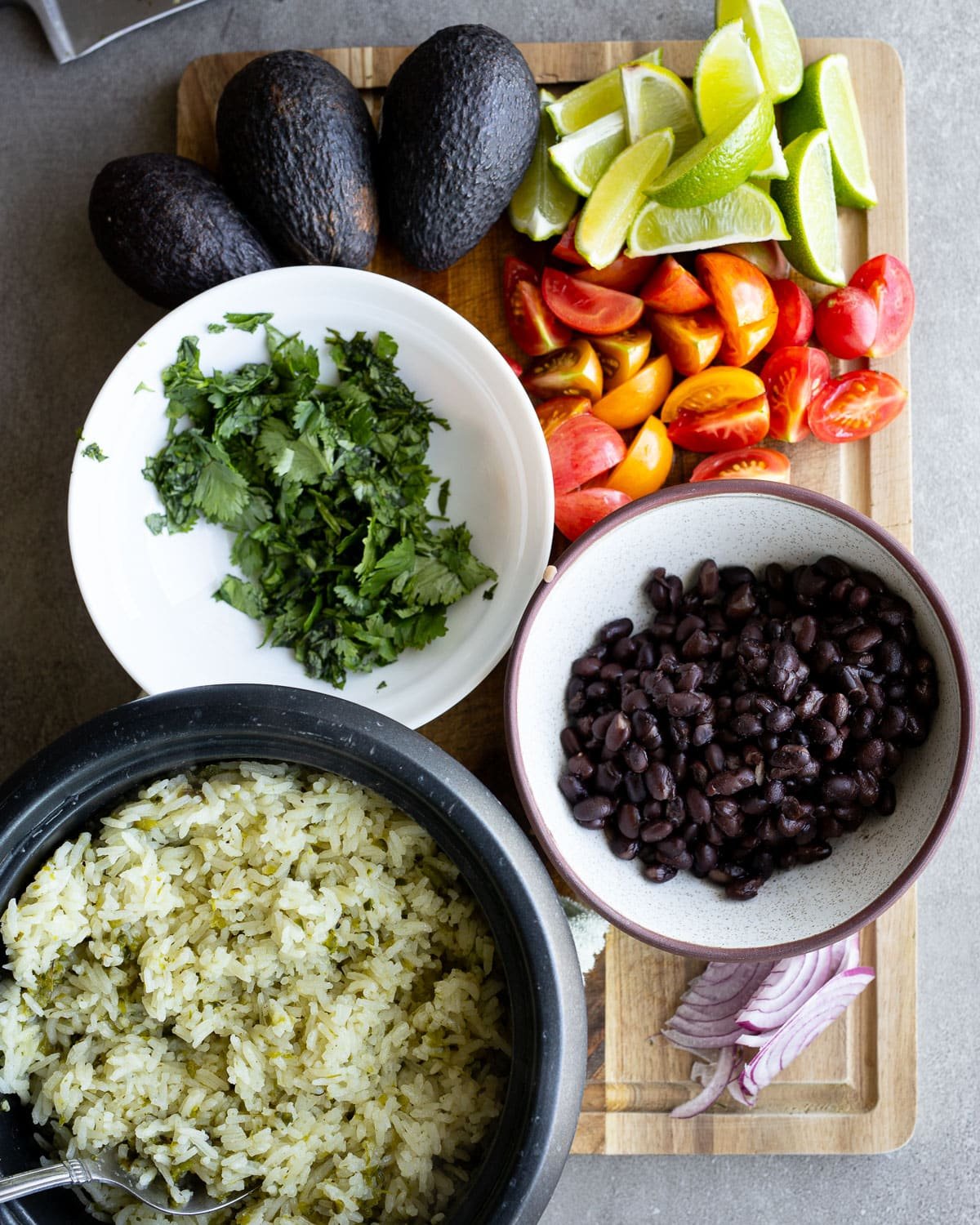 Ingredients to create buddha bowls on a wooden cutting board.