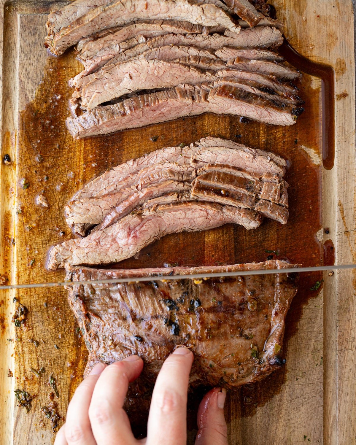 Woman slicing flank steak for carne asada.