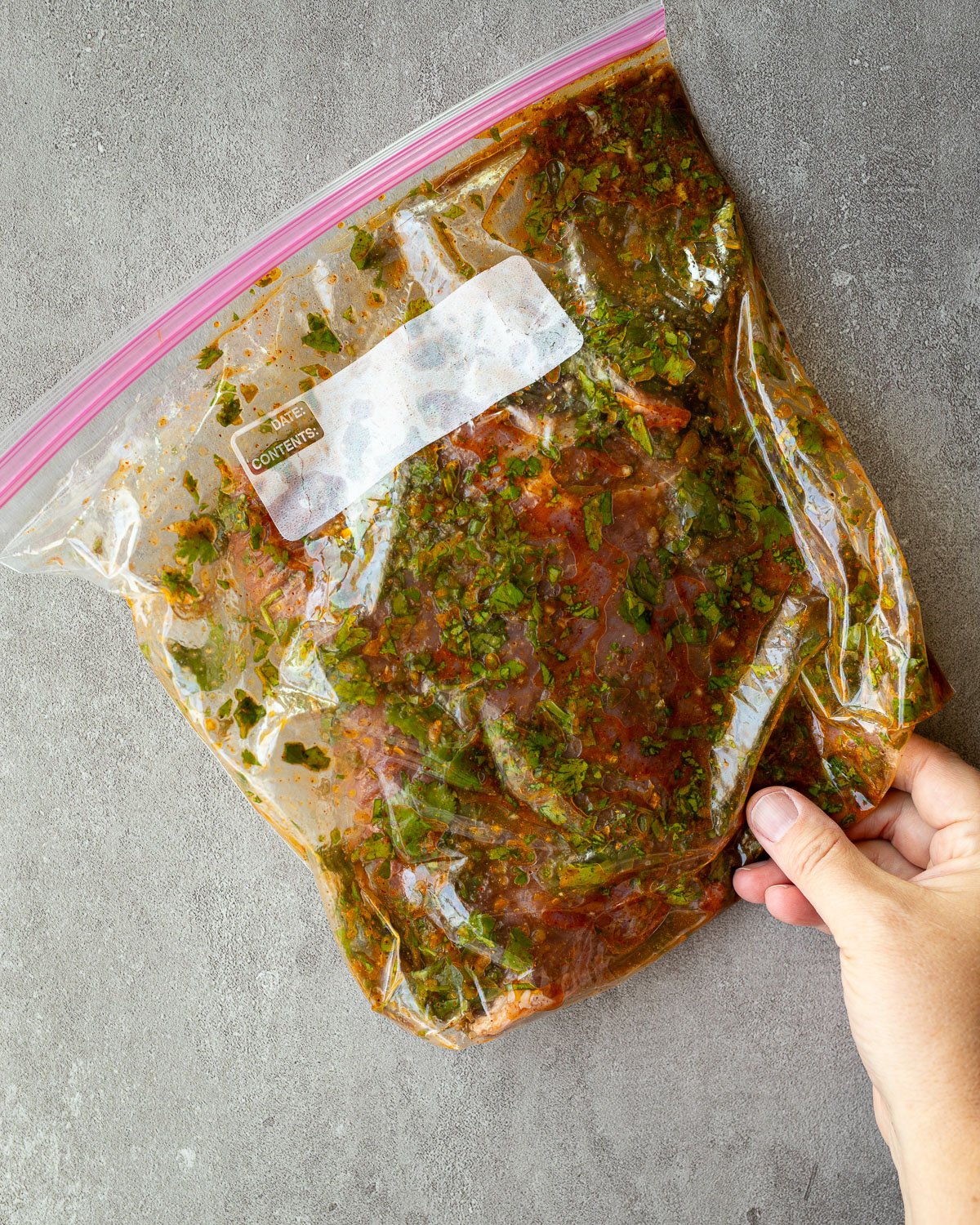 Flank steak marinating in a plastic bag for carne asada.